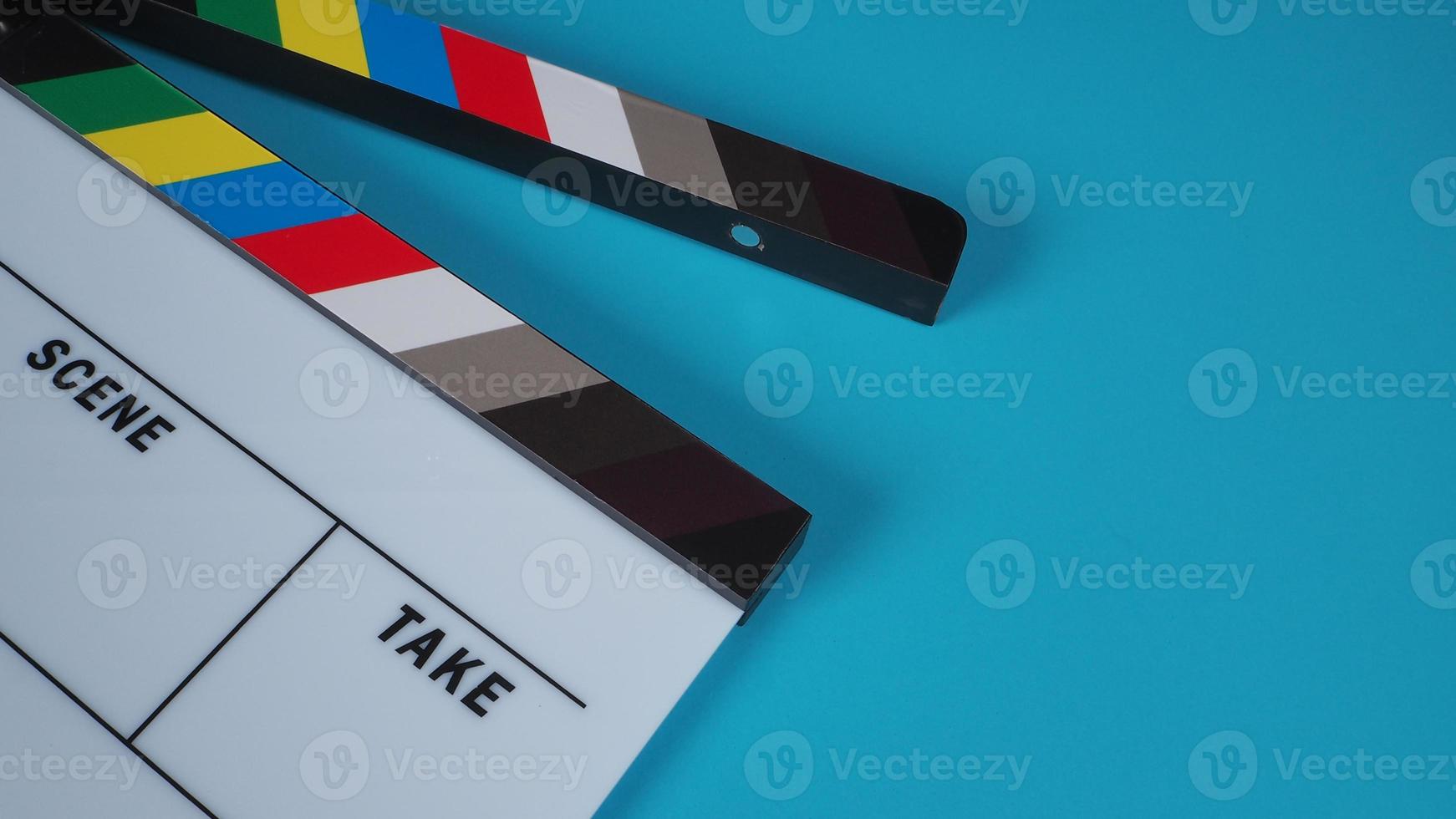 Clapperboard or movie slate on blue background. photo