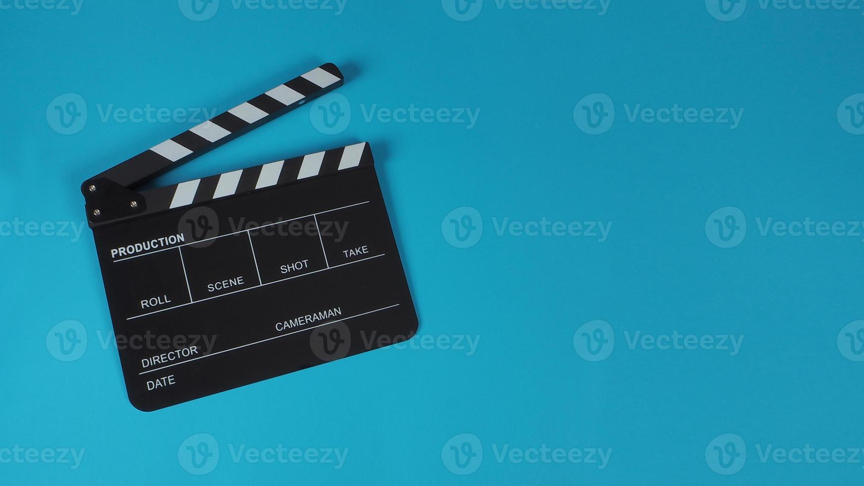 Clapperboard or movie slate use in cinema industry on blue background. photo