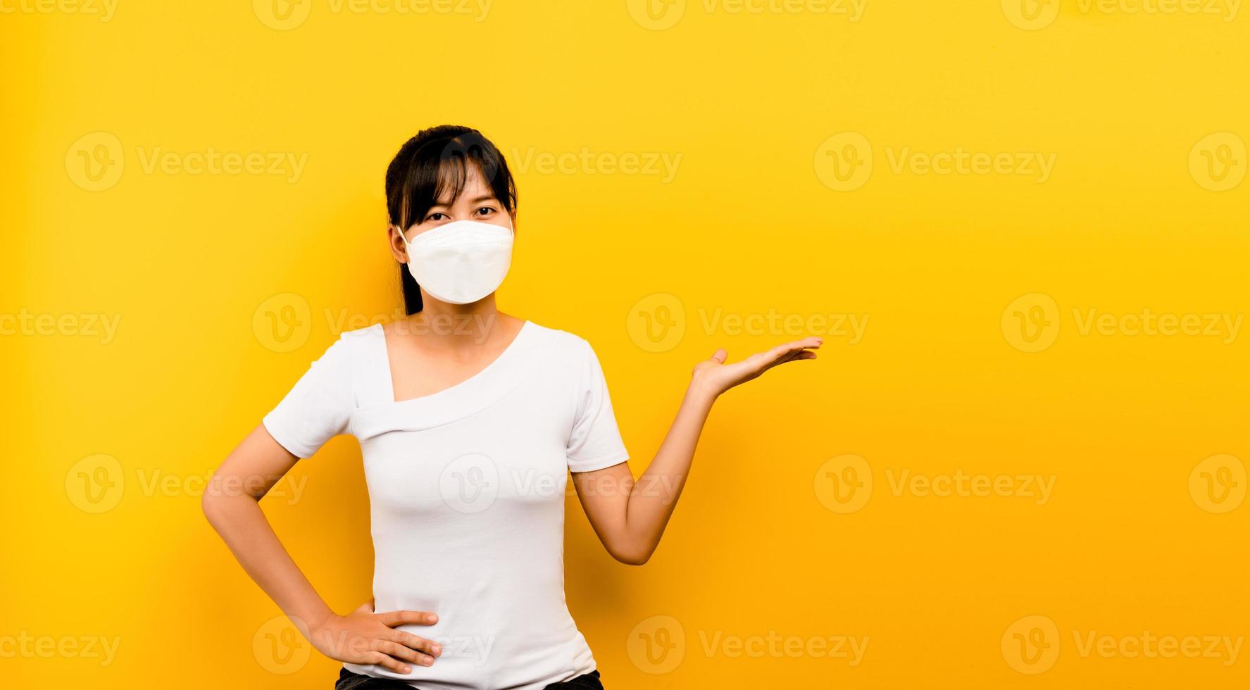 Mujer asiática mostrando llevar máscara antivirus para proteger foto