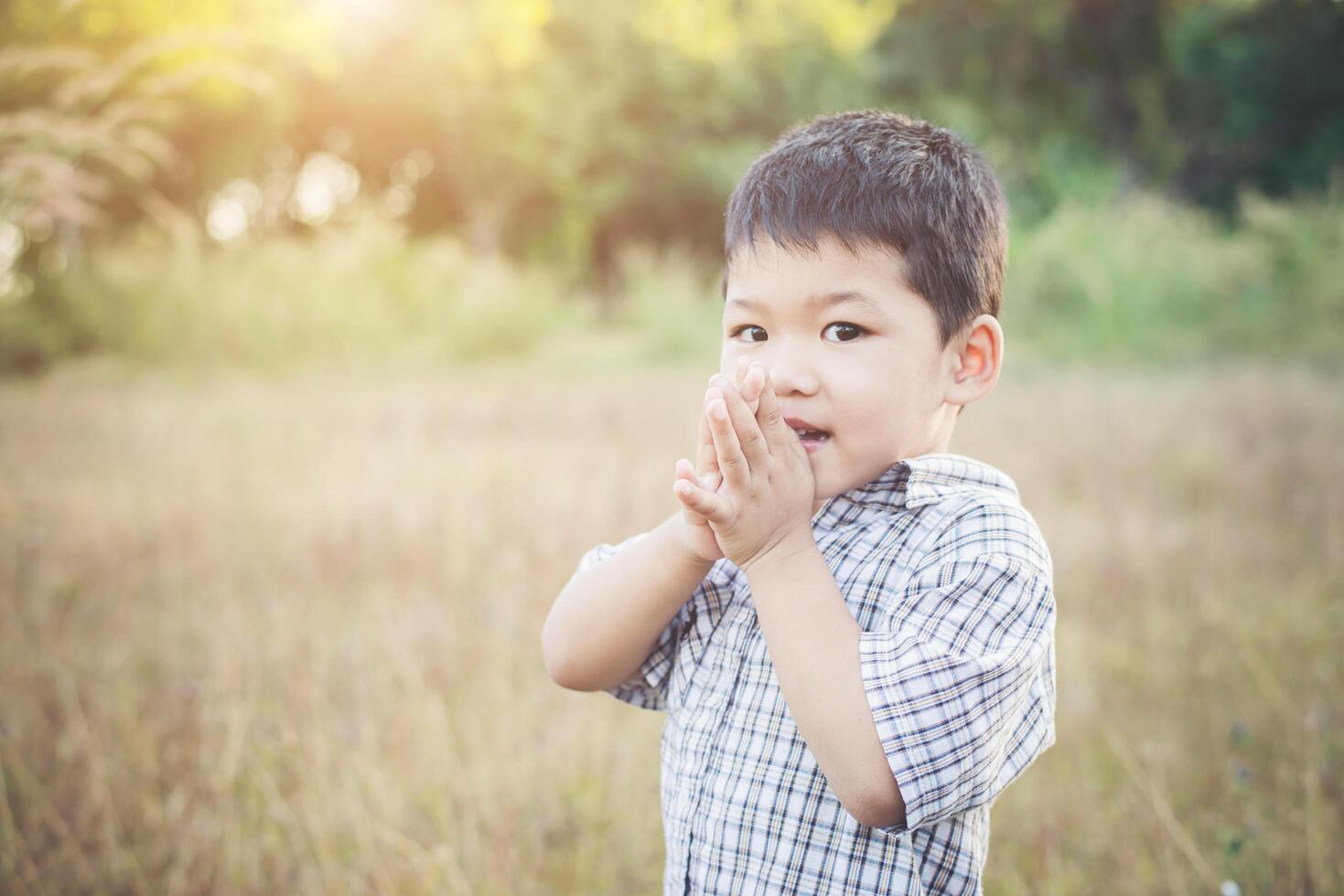 Happy little asian boy playing outdoors. Cute asian. boy on field. photo