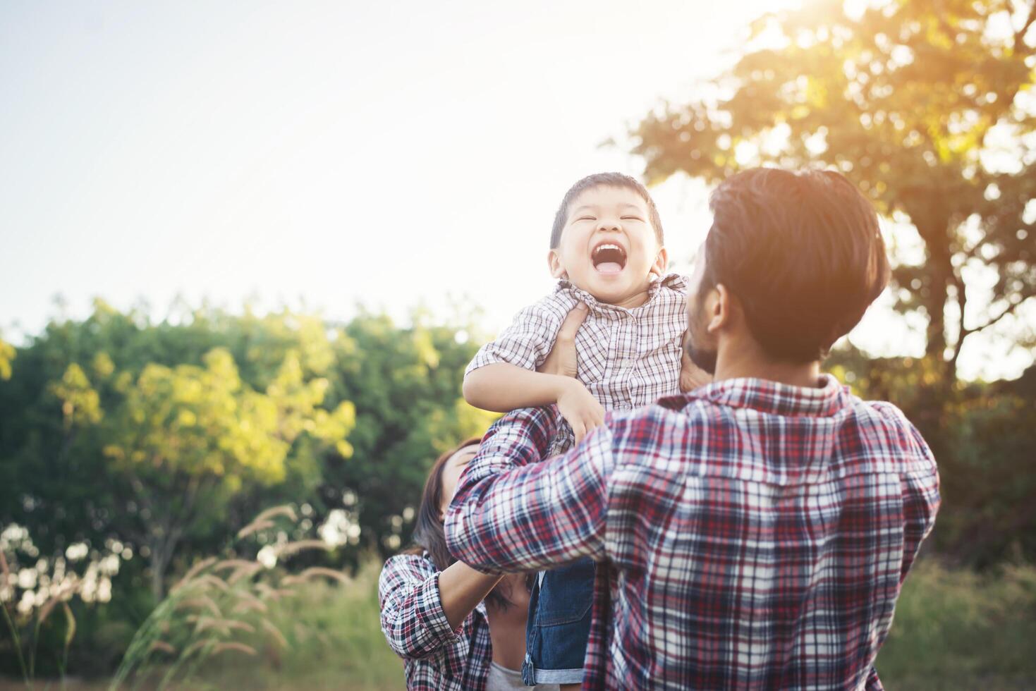 familia joven feliz pasar tiempo juntos afuera. concepto de amor familiar foto