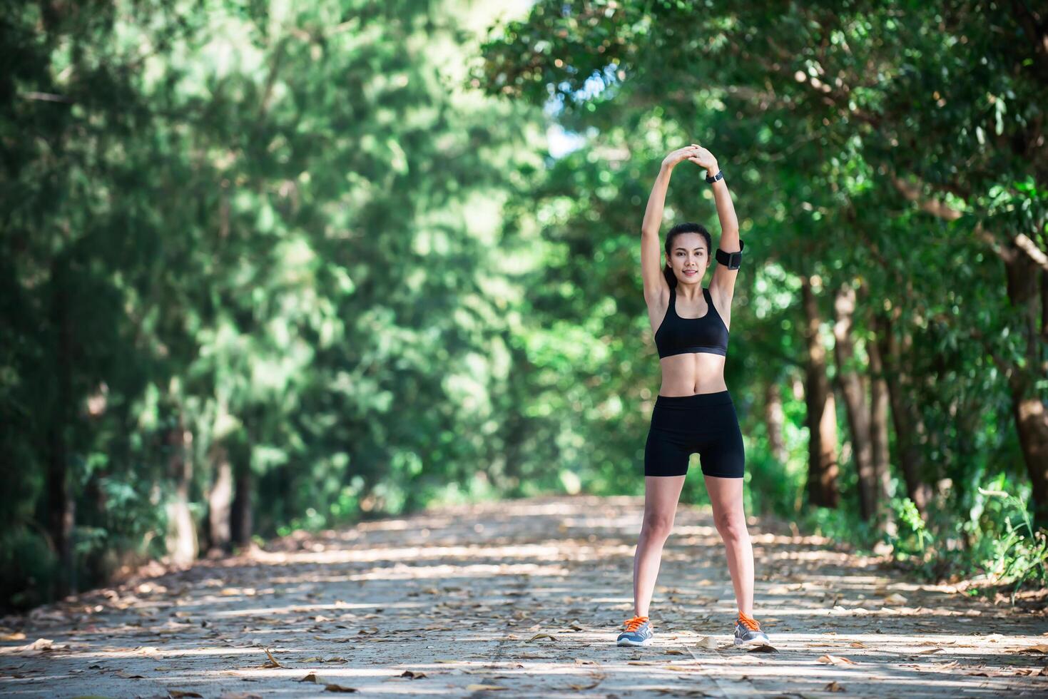 mujer joven fitness estirando las piernas antes de correr. foto