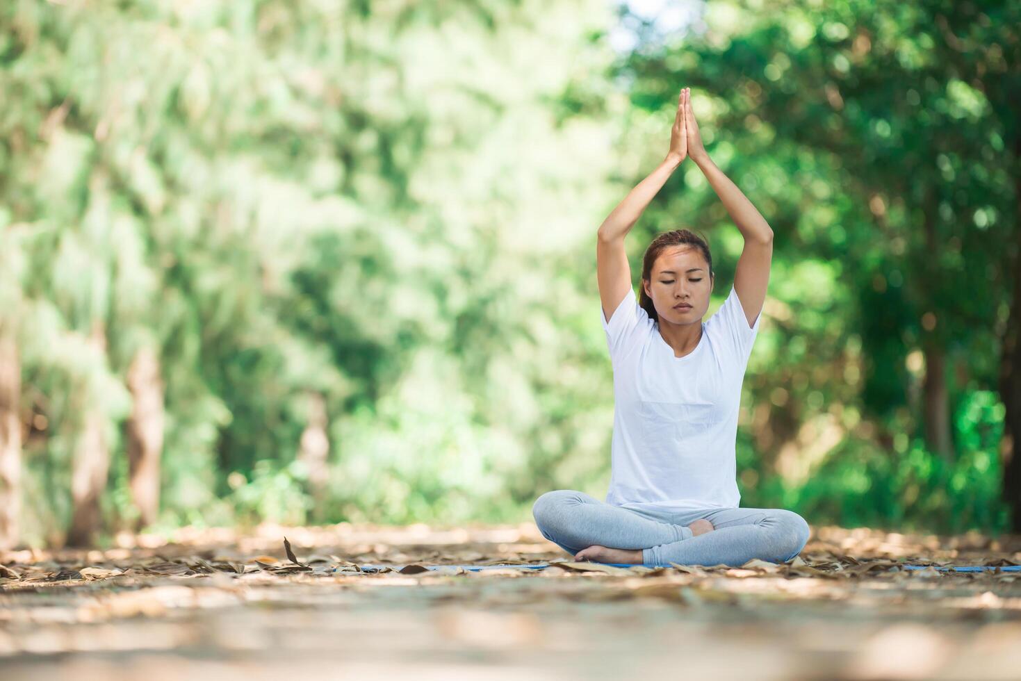 joven asiática haciendo yoga por la mañana en el parque. foto