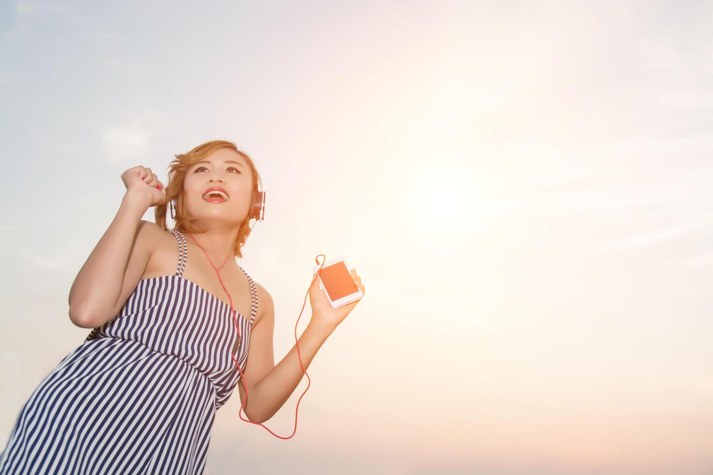 Beautiful sexy young woman lying nearing headphone in the flower field photo