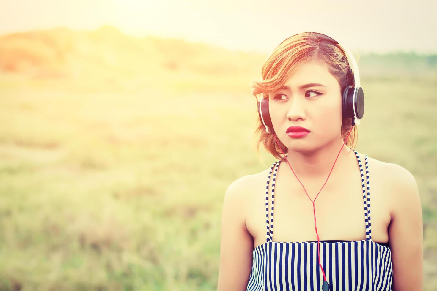 beautiful sexy woman standing listening sad music in the flower fields photo