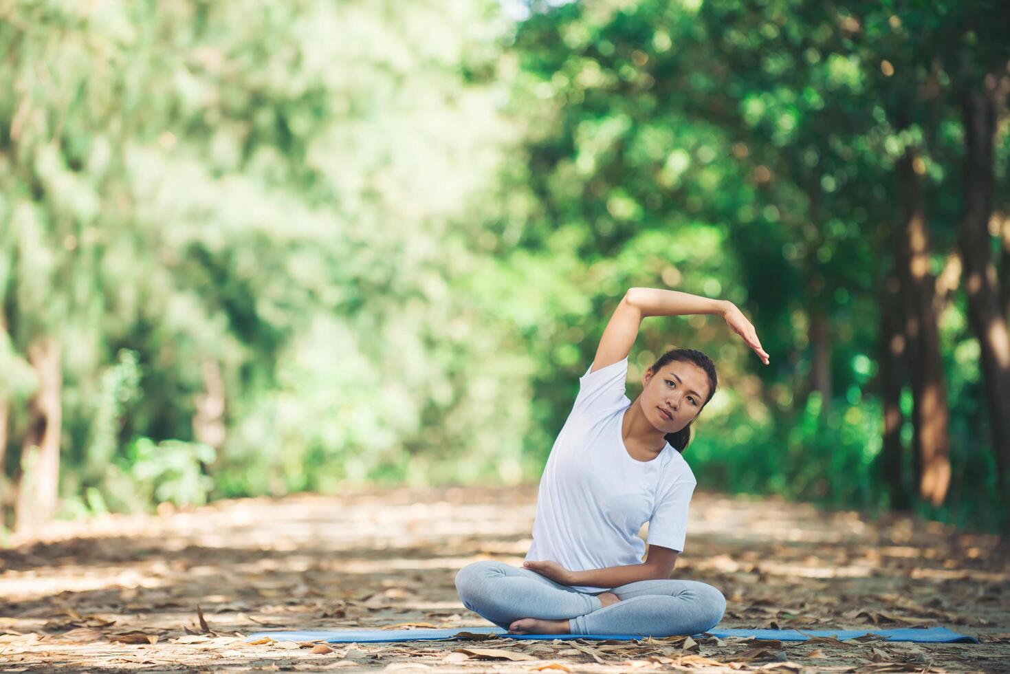 joven asiática haciendo yoga por la mañana en el parque. foto