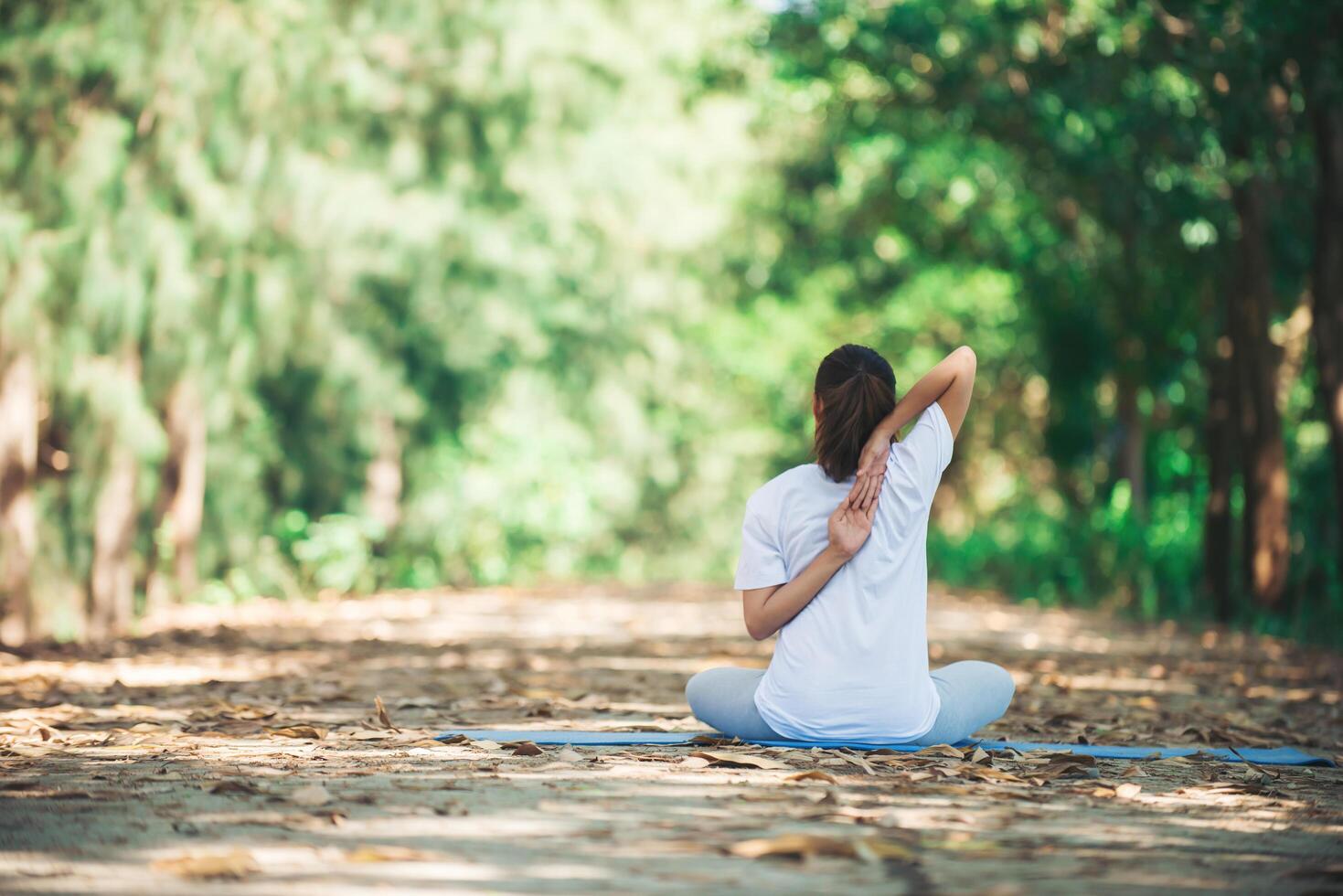 joven asiática haciendo yoga por la mañana en el parque. foto