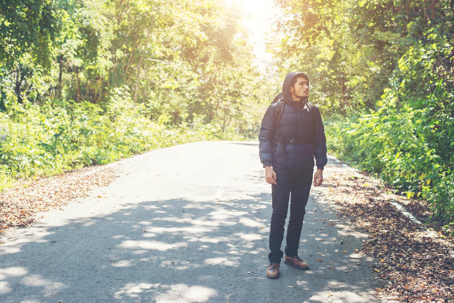 Hiker man walking on the rural road. Holiday tourism concept. photo