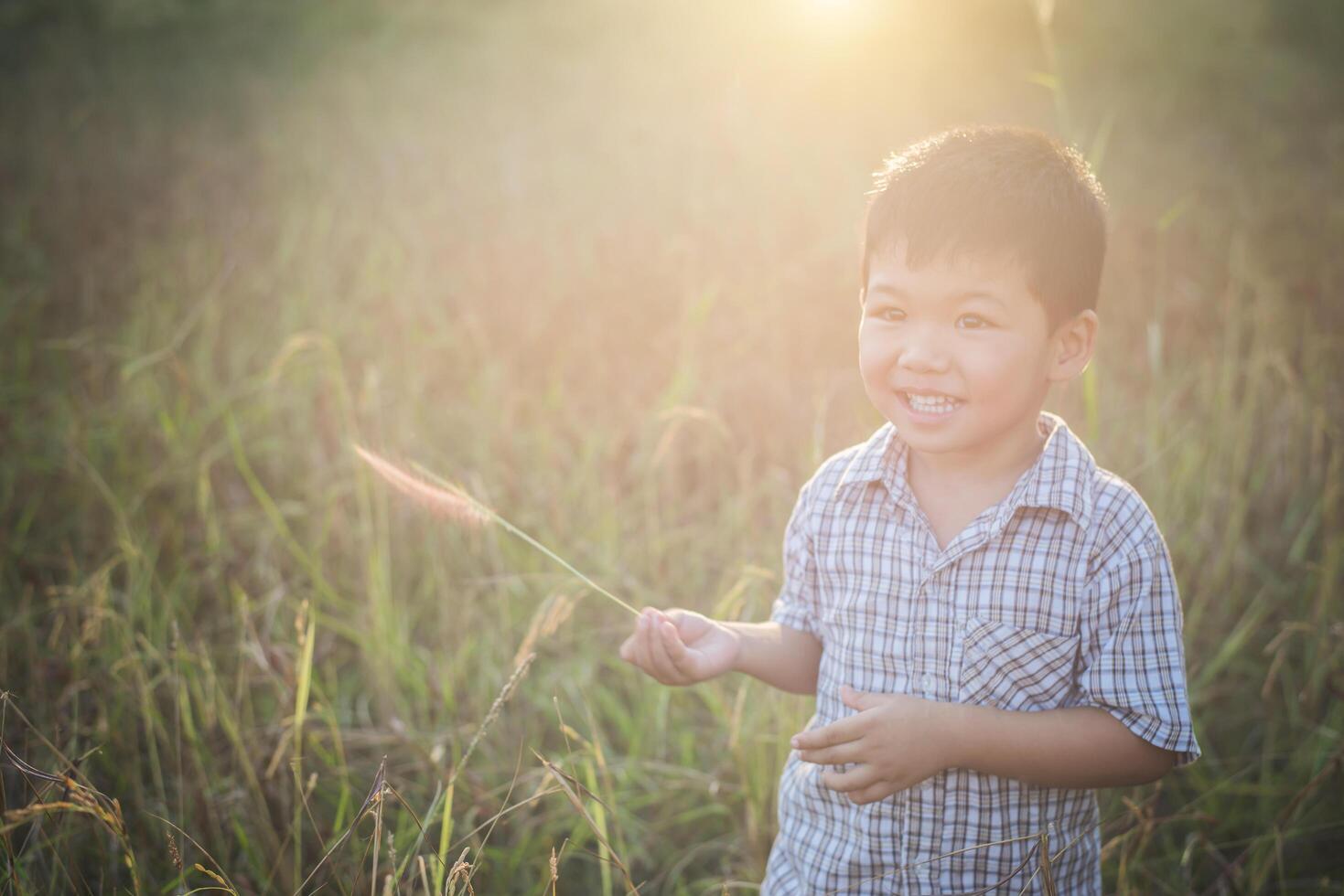 Happy little asian boy playing outdoors. Cute asian. boy on field. photo