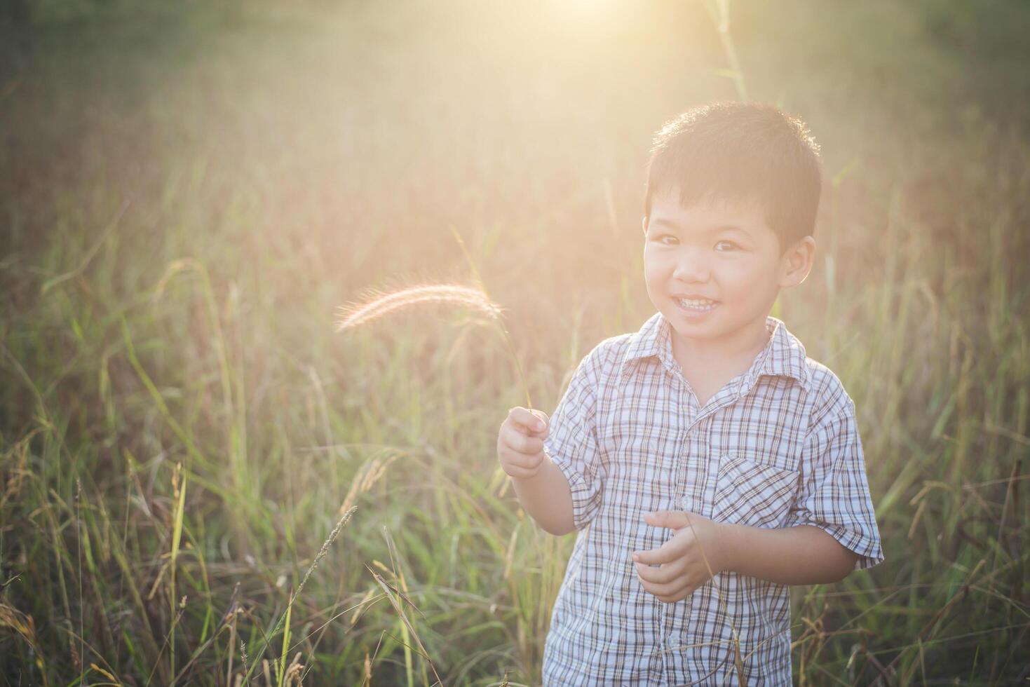 niño asiático feliz jugando al aire libre. lindo asiático. chico en el campo. foto