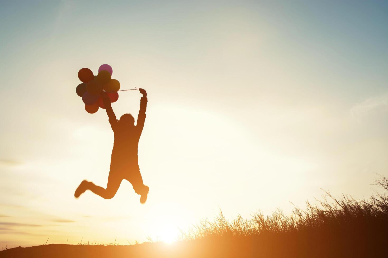 young woman with balloons jumping outdoor photo