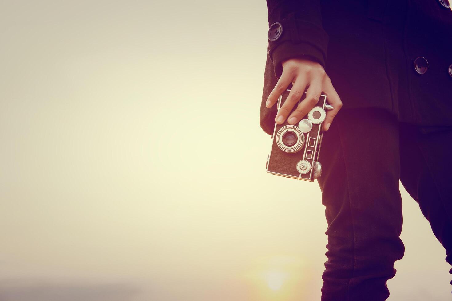 Young woman hands holding retro camera close-up photo