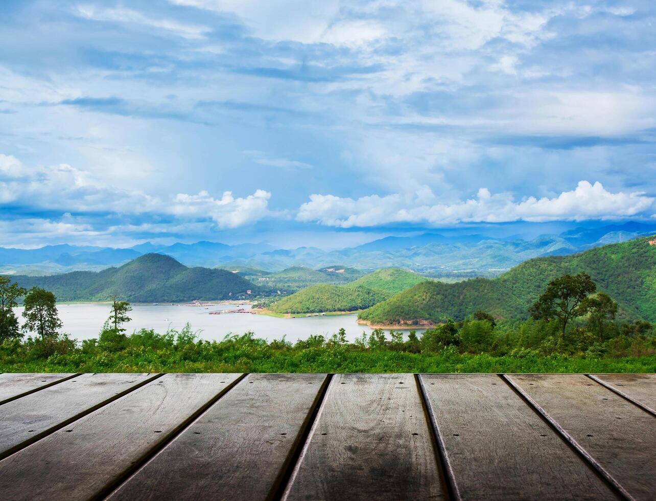 Piso de tablones de madera con fondo de naturaleza de belleza de vista a la montaña foto