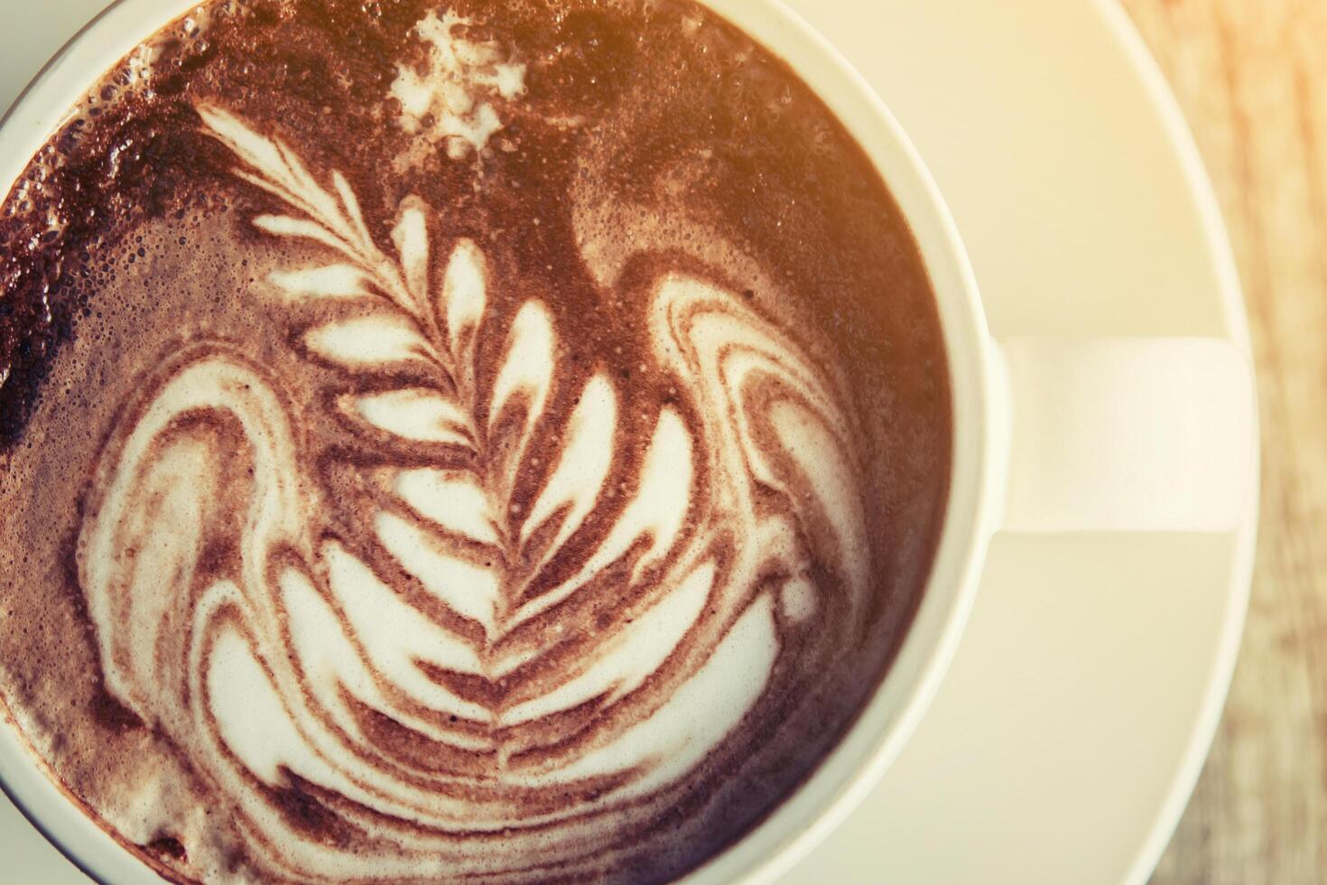 tazas blancas de café capuchino con espuma de leche en forma de árbol. foto