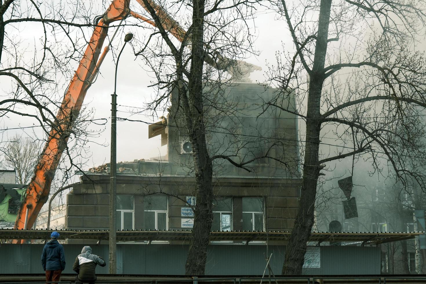 Demolition of house process with mechanical crushing claws photo