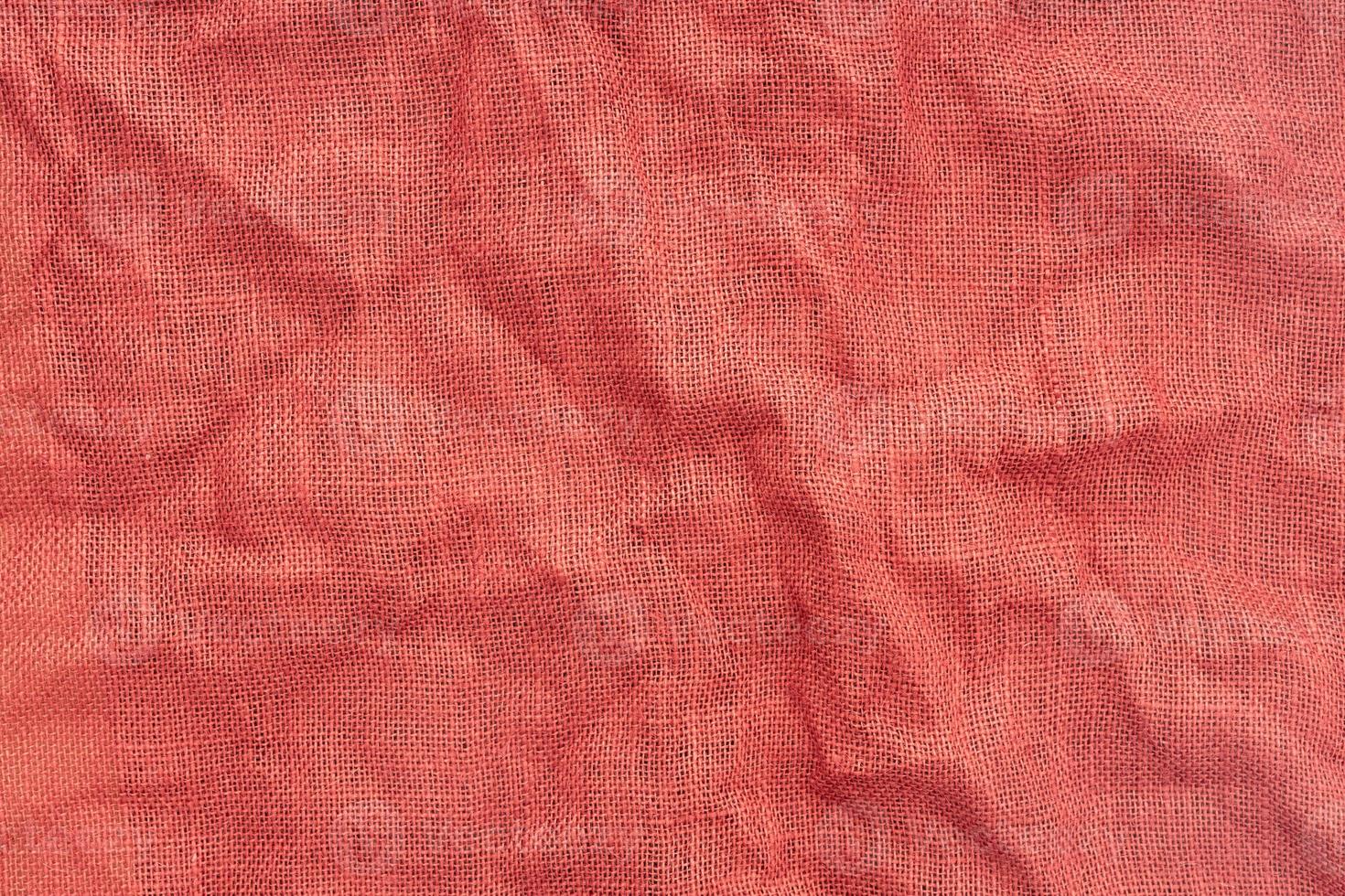 Tela de arpillera roja con textura de fondo de arrugas. fotograma completo foto