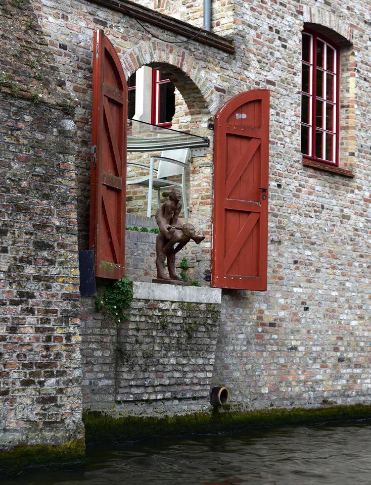 Brujas, Bélgica - 29 de abril 19, escultura divertida en una puerta en el lado del canal foto