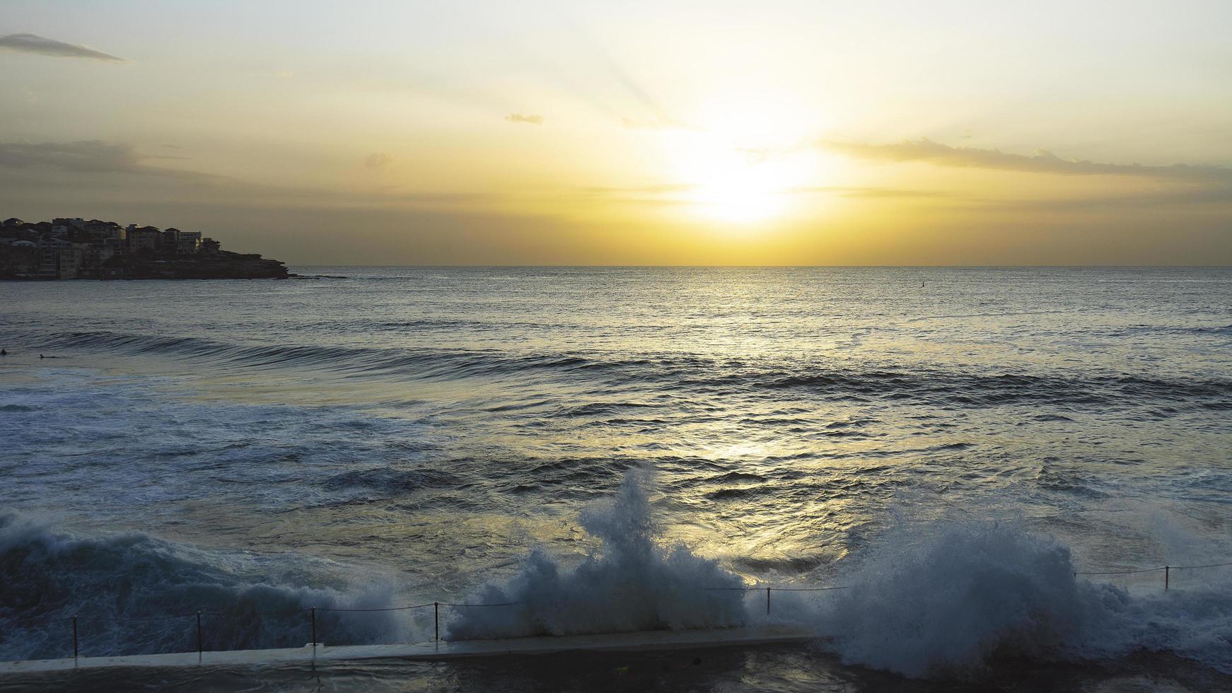 sea waves crashing on shore during sunset photo