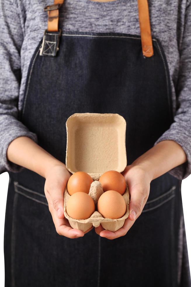 Mujer sosteniendo huevos de gallina frescos en caja de cartón foto