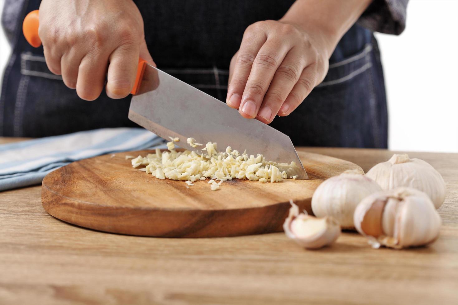 Chef ajo picado sobre tabla de cortar de madera foto