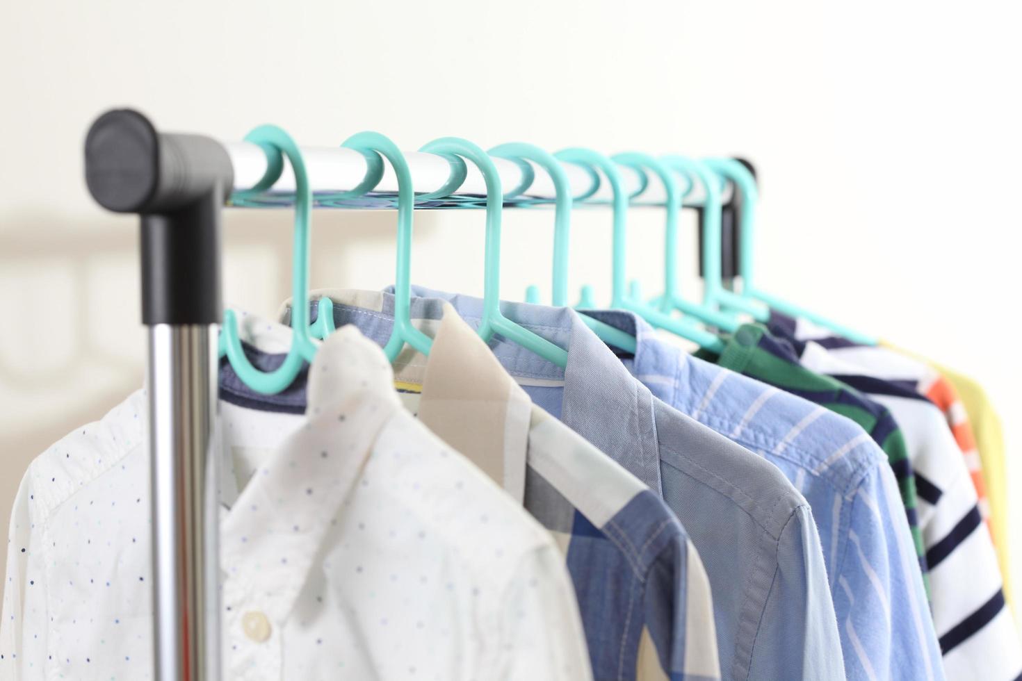 camisas de niño en colores pastel colgadas en el estante foto