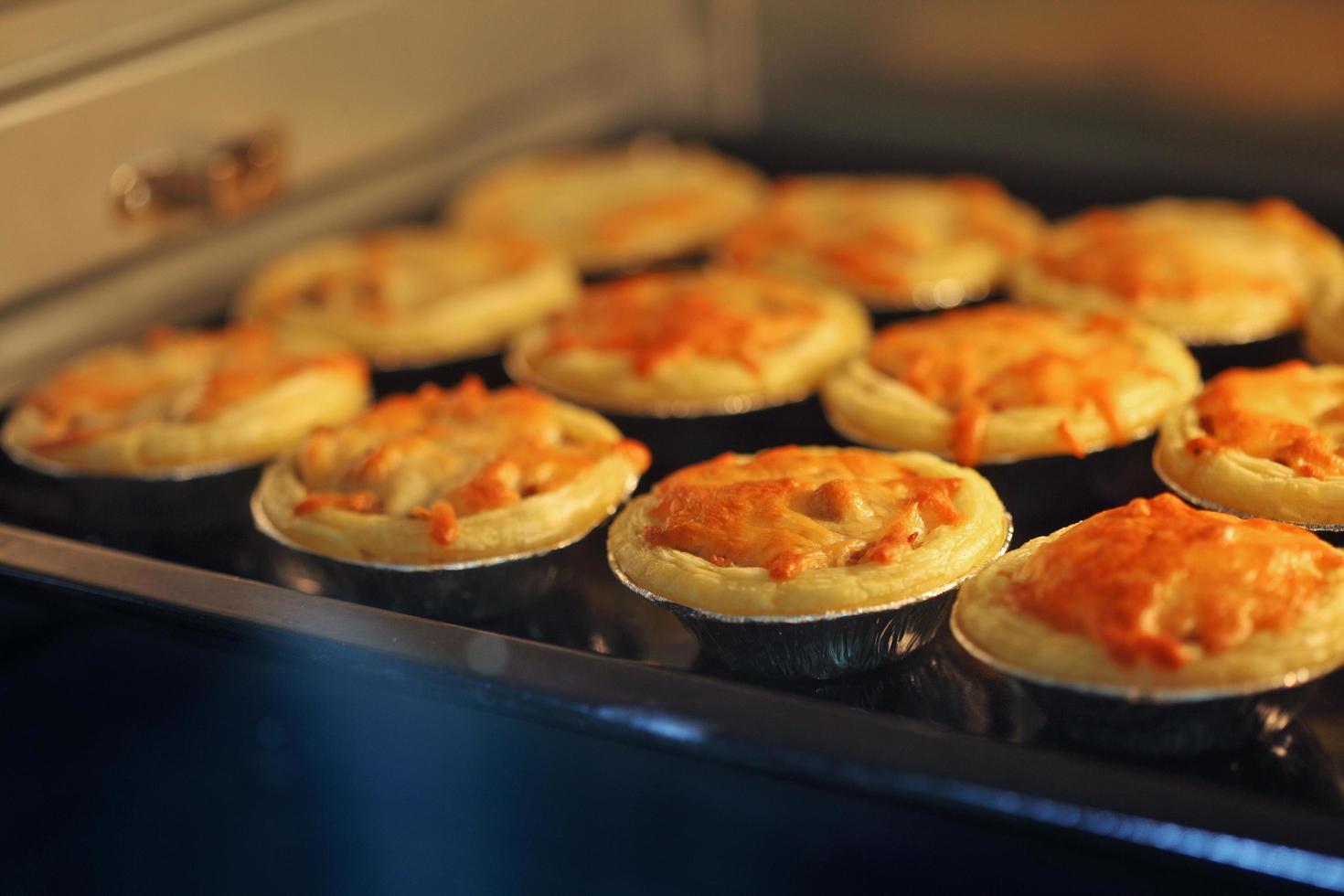 Mini pie from meat and mushrooms baking in industrial oven photo