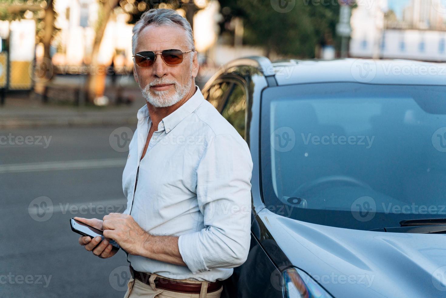 Middle aged man standing near his SUV car photo