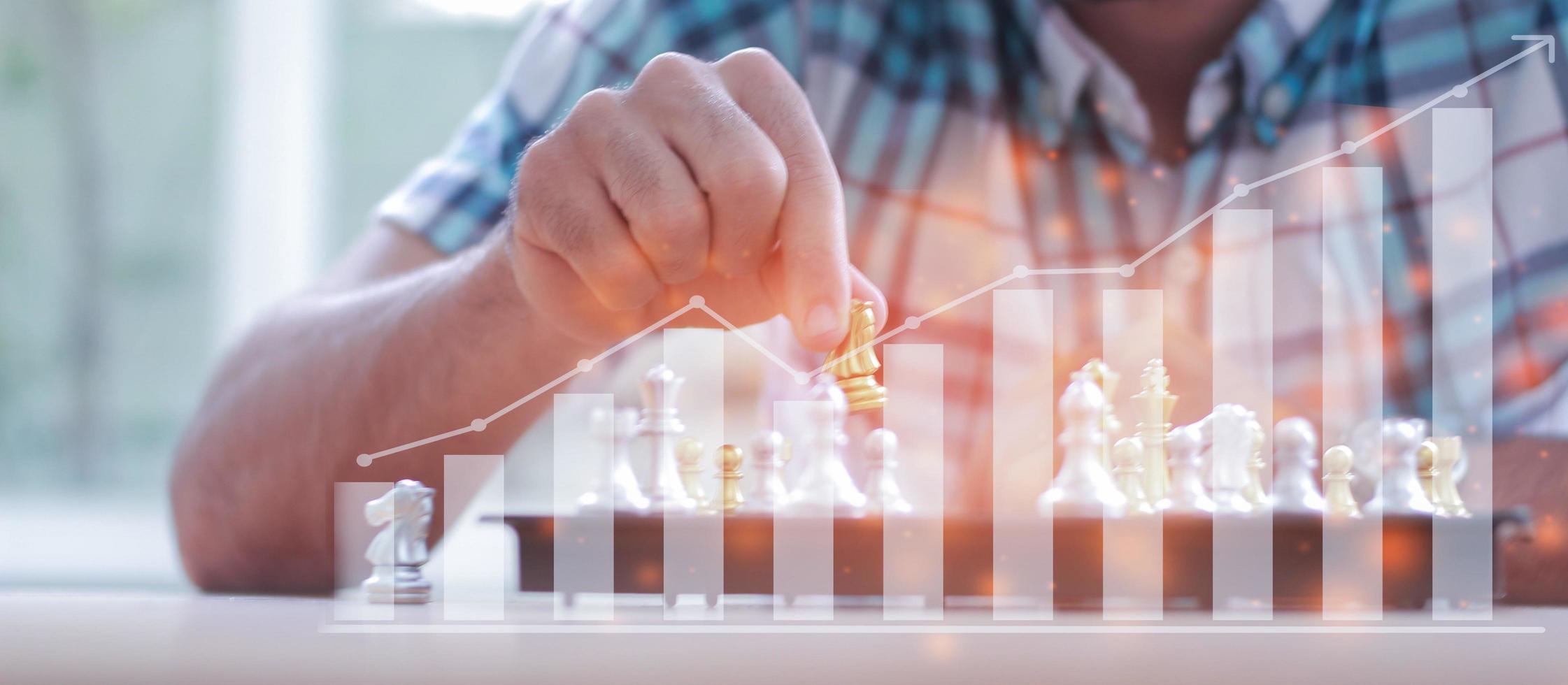 Businessman playing with a chess game finding strategies photo