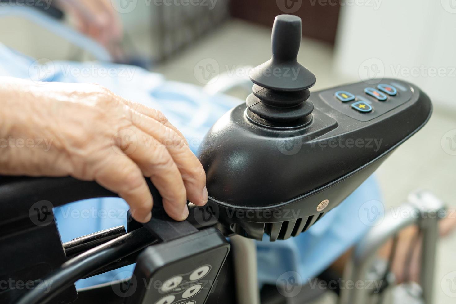 Asian senior woman patient on electric wheelchair at nursing hospital photo