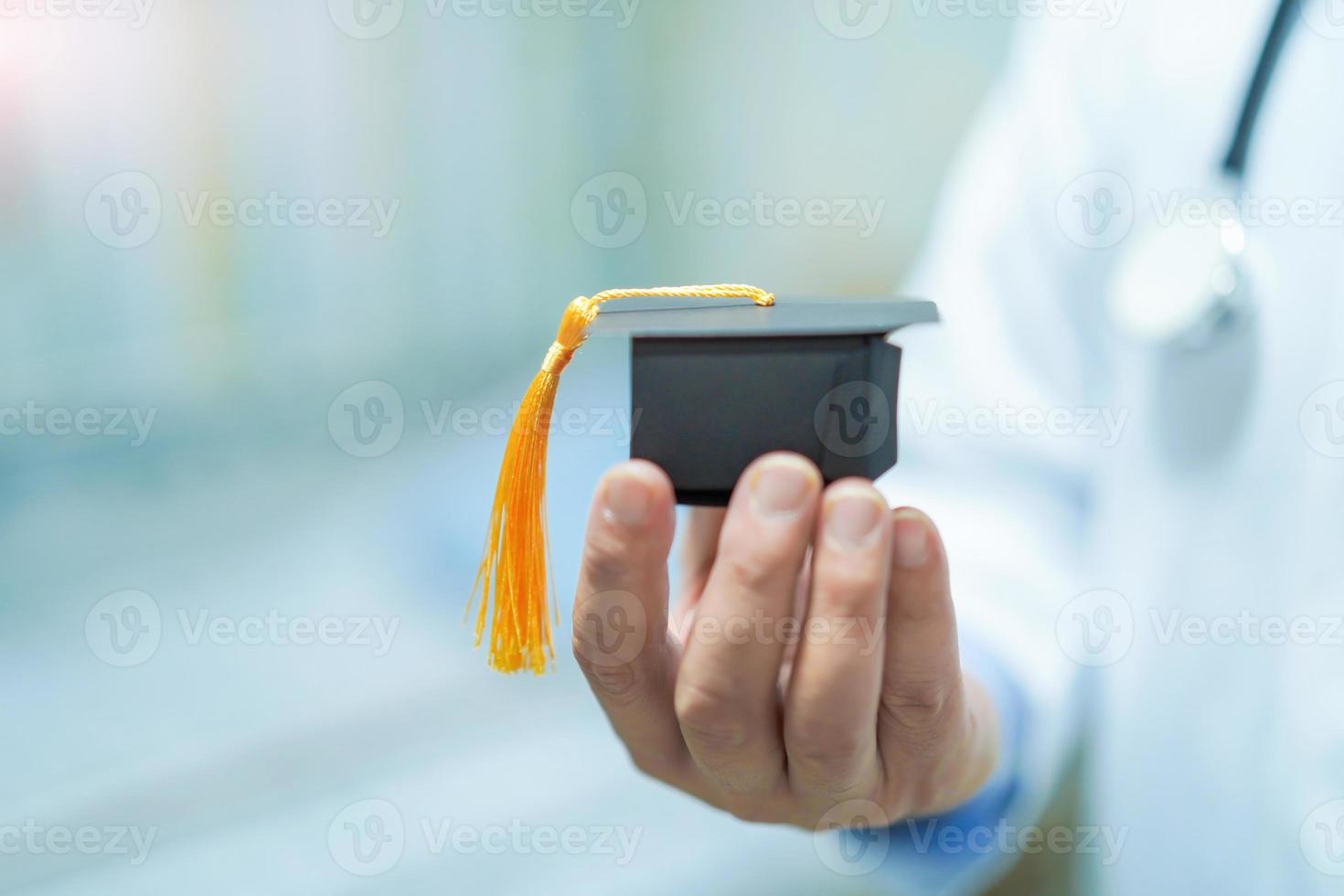 Doctor holding graduate hat for education. photo