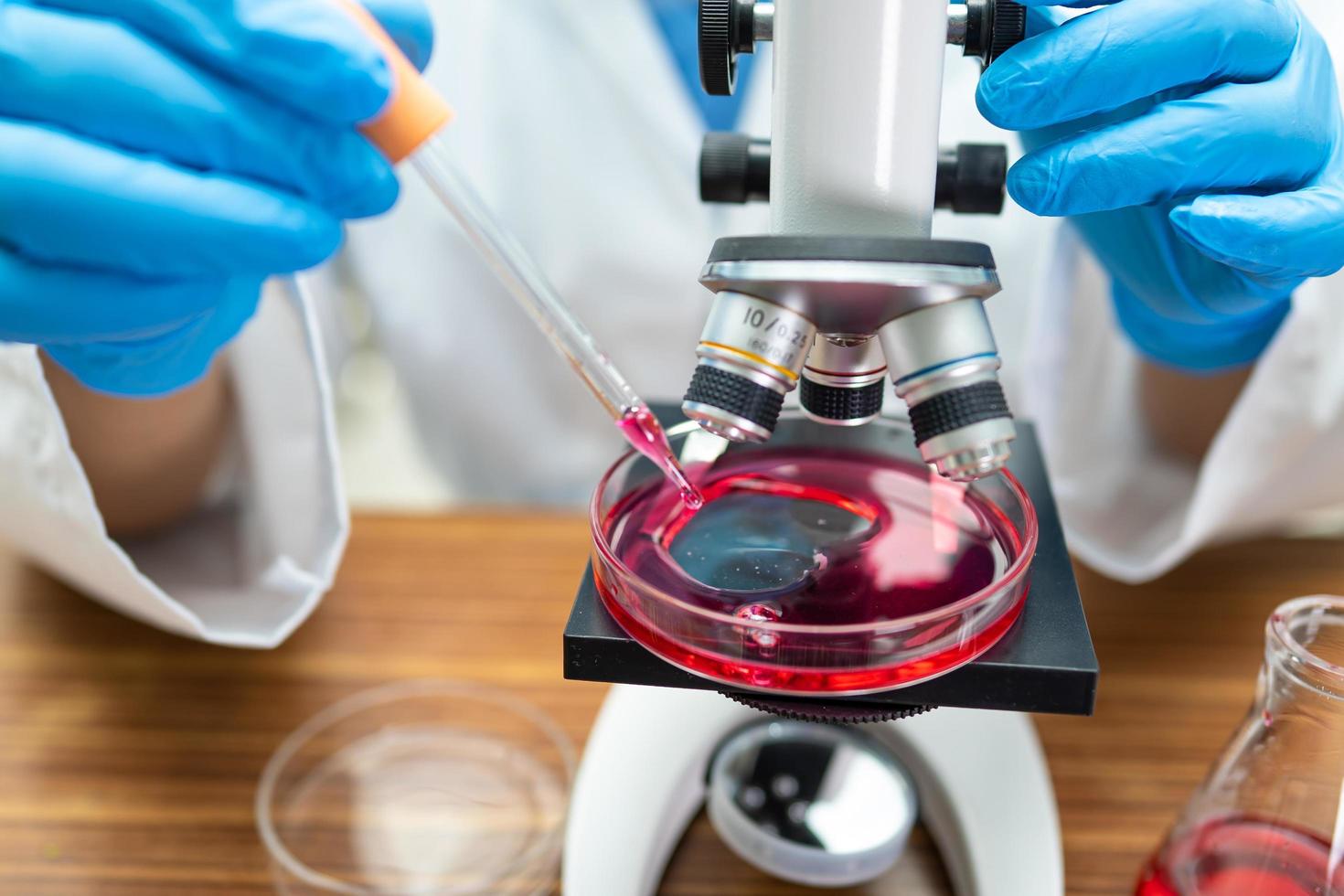 Asian scientist working research with a microscope photo