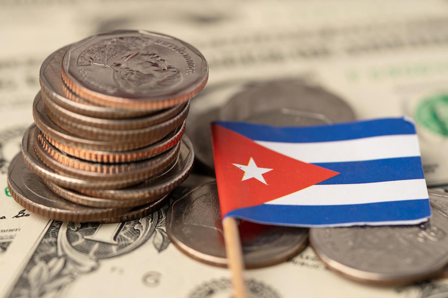 Stack of coins with Cuba flag on USA dollar banknotes background. photo