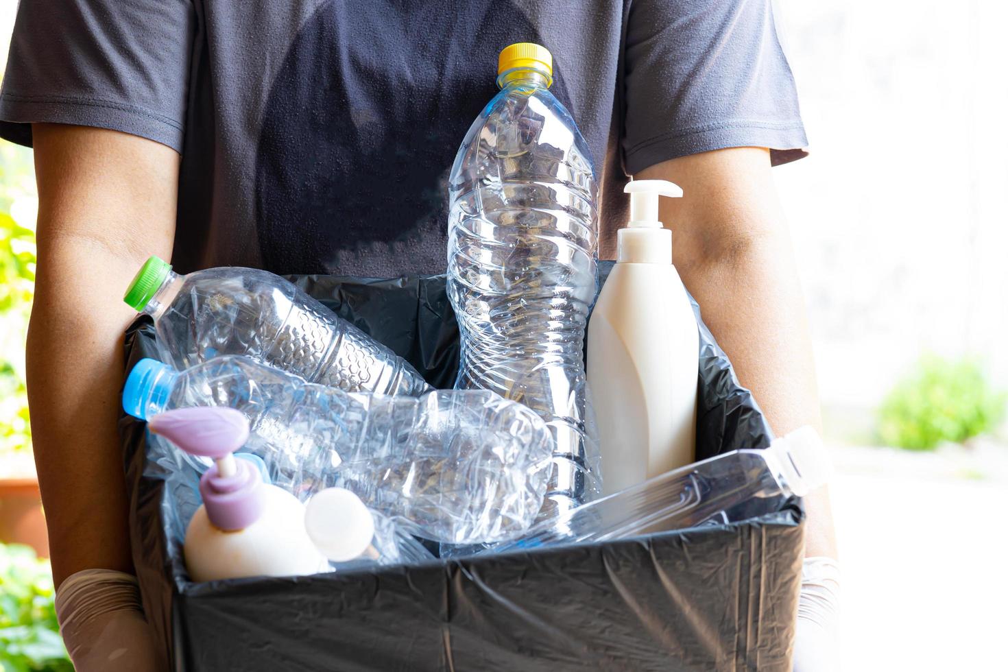 Mujer sosteniendo botellas de plástico basura en caja para reutilizar reciclar foto