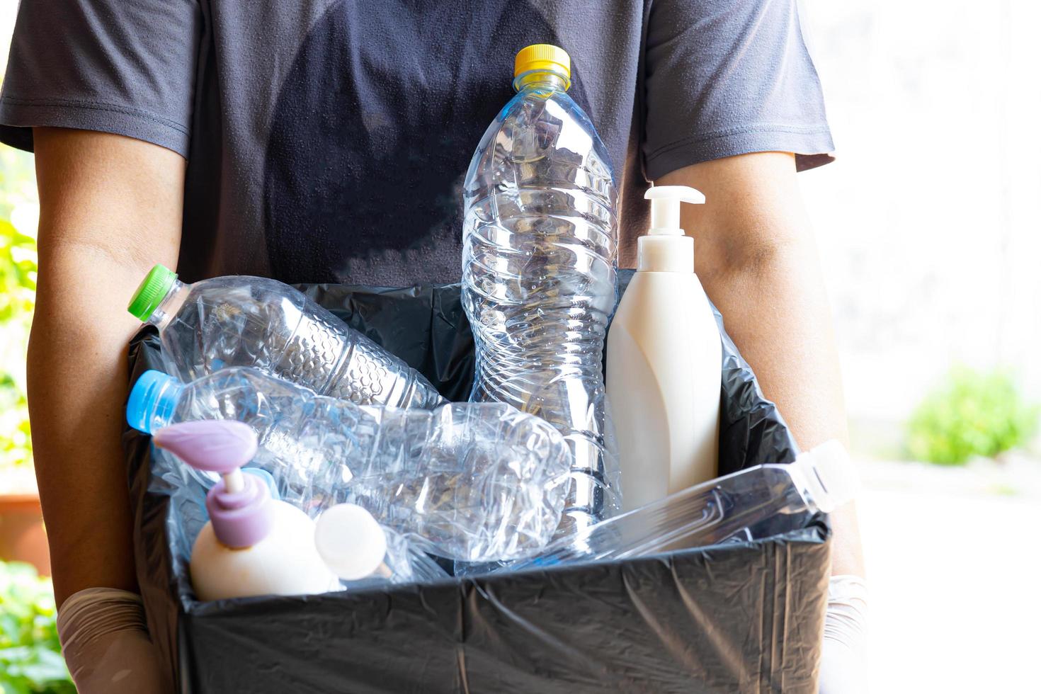 Woman holding plastic bottles garbage in box to reuse recycle photo