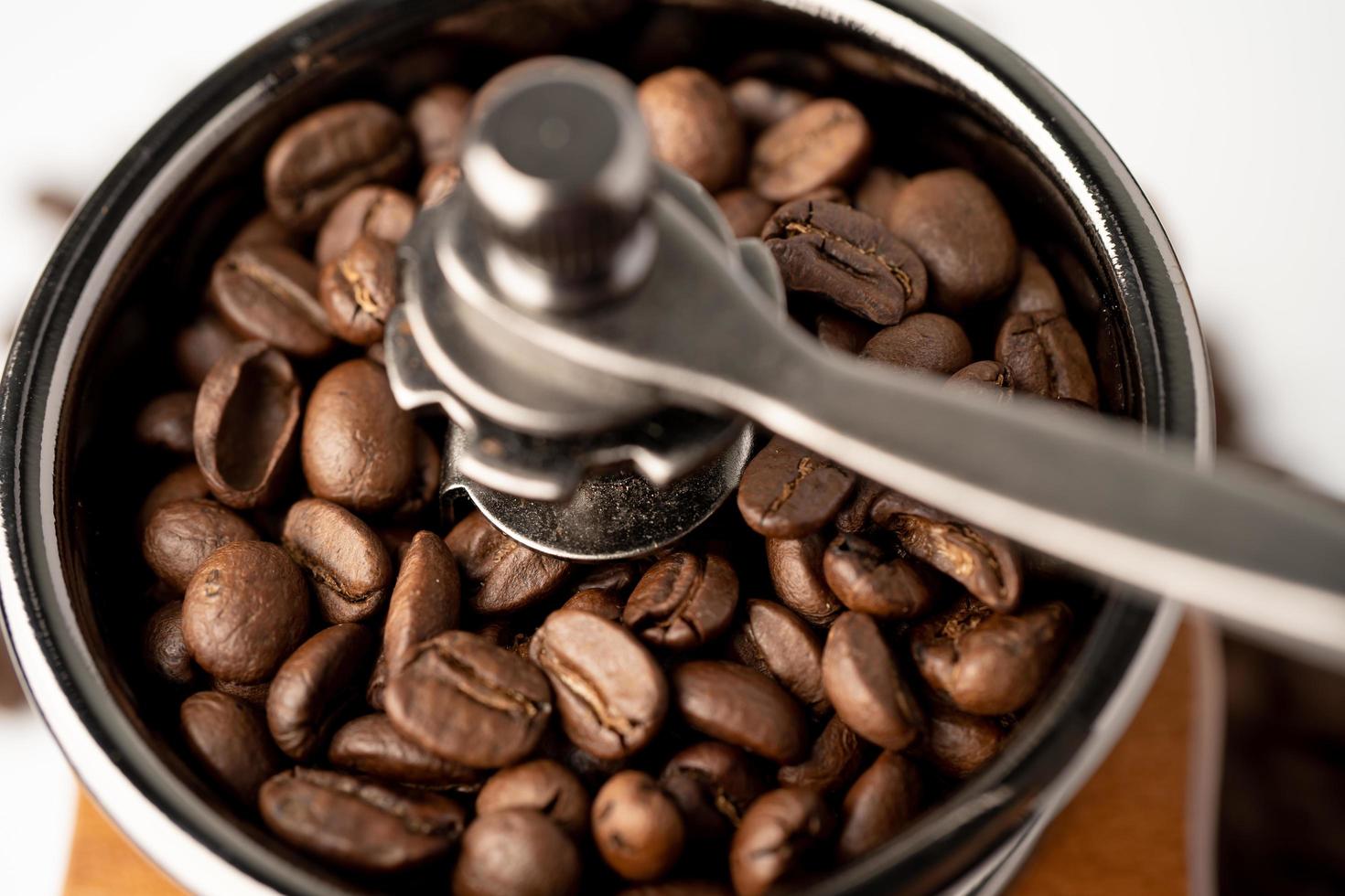 Coffee bean roasted in wooden grinder on white background. photo
