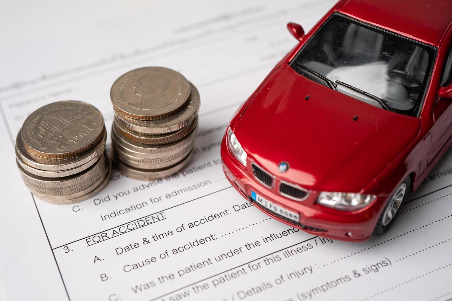Car and coins on Insurance claim accident car form photo