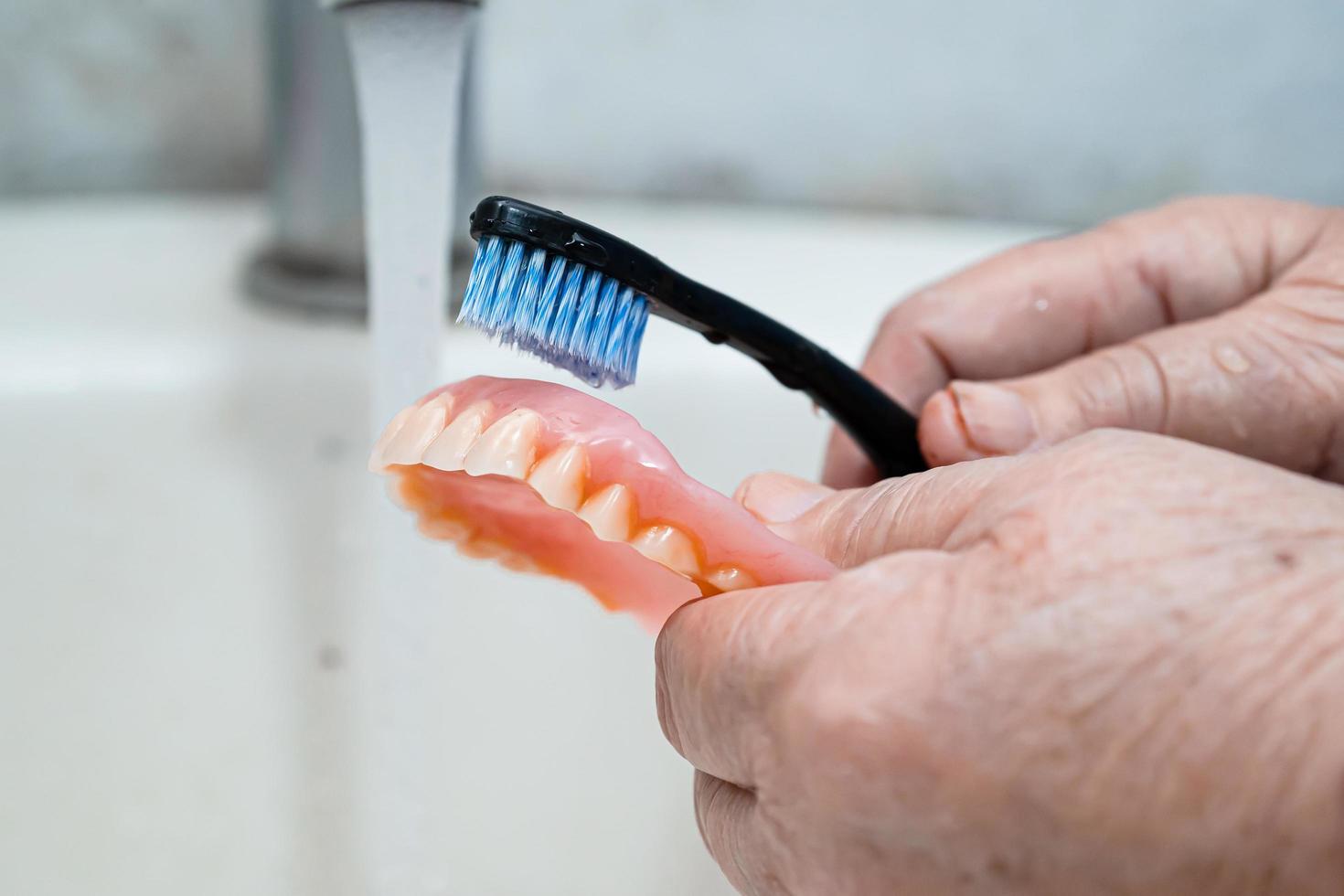 Paciente mujer mayor asiática usar cepillo de dientes foto