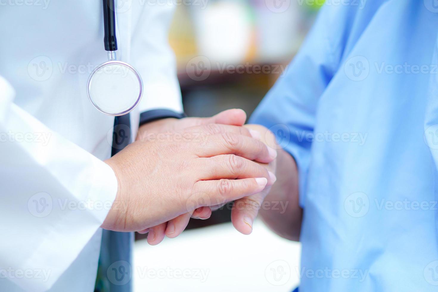 Doctor sosteniendo la mano paciente mujer senior asiática en el hospital foto