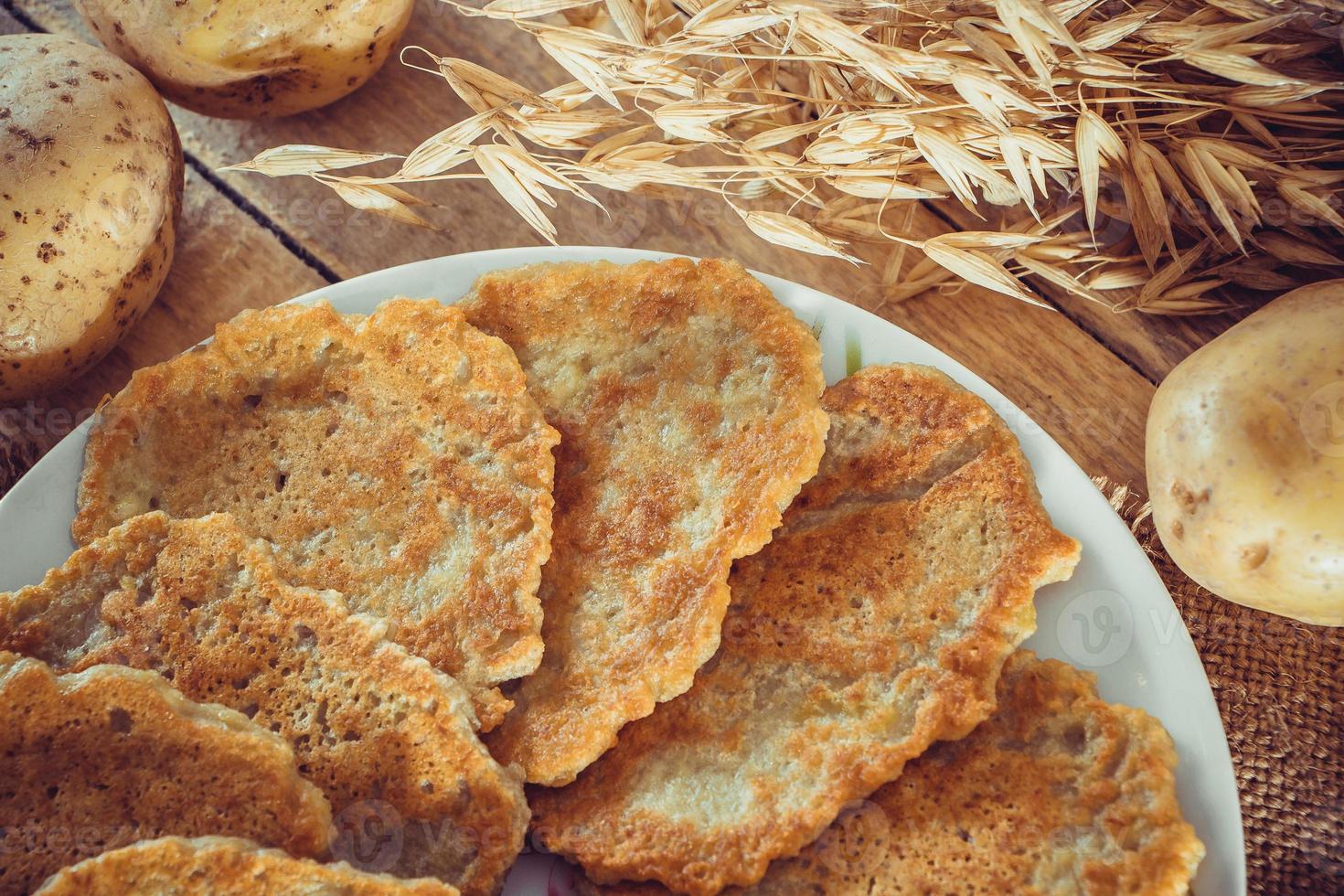 Potato pancakes on a plate and fork on linen background photo