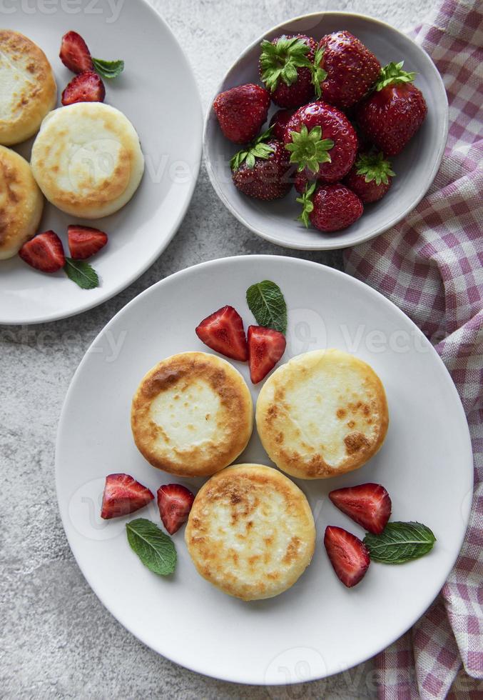 panqueques de requesón en plato de cerámica con fresa fresca. foto