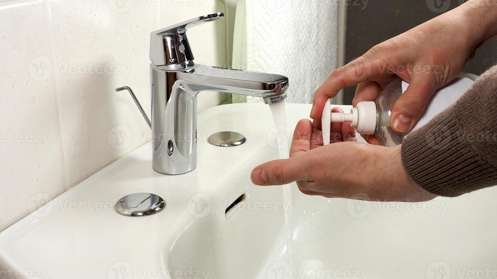 Unrecognisable man washing hands photo