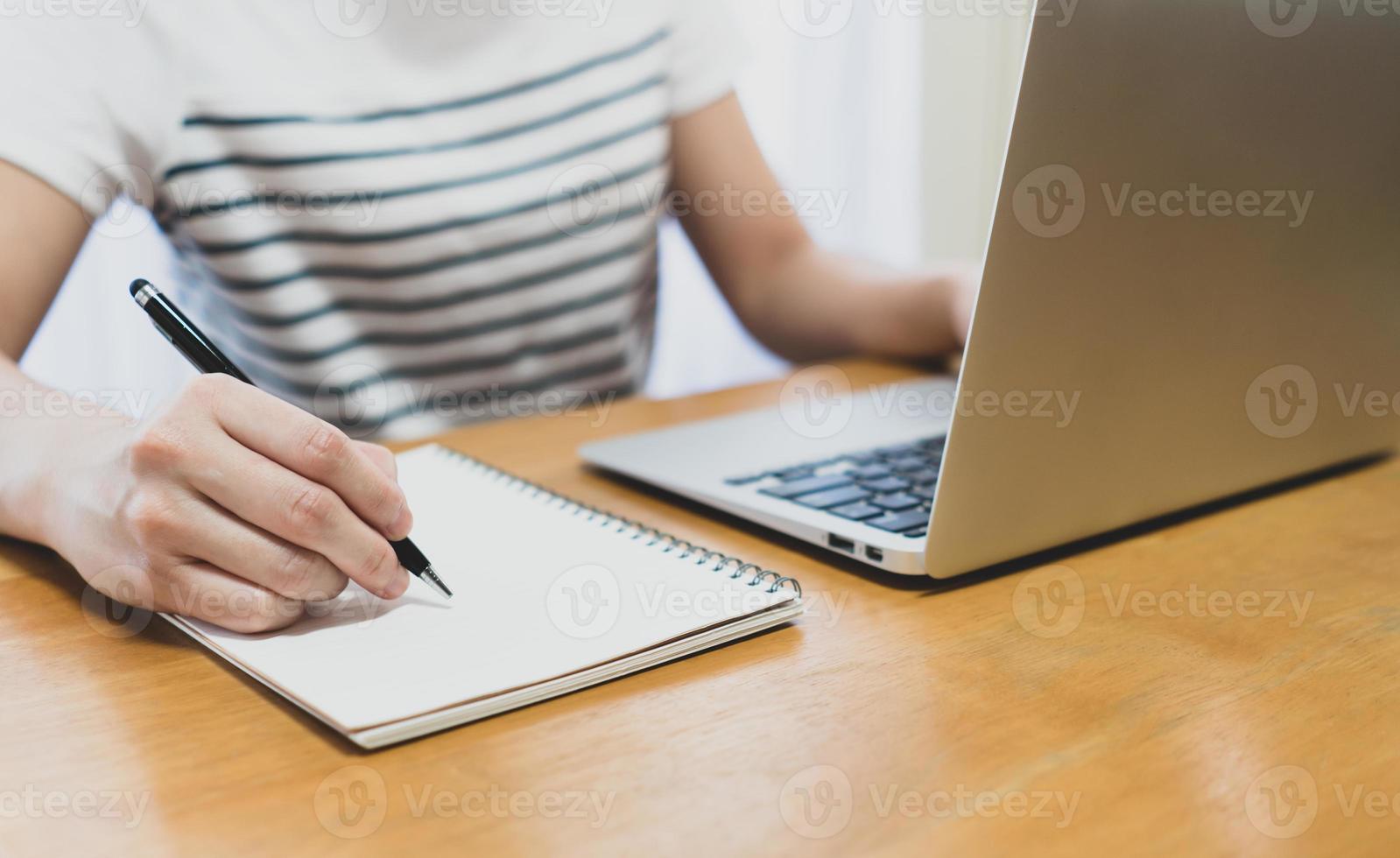 mujer que usa la computadora para trabajar desde casa foto