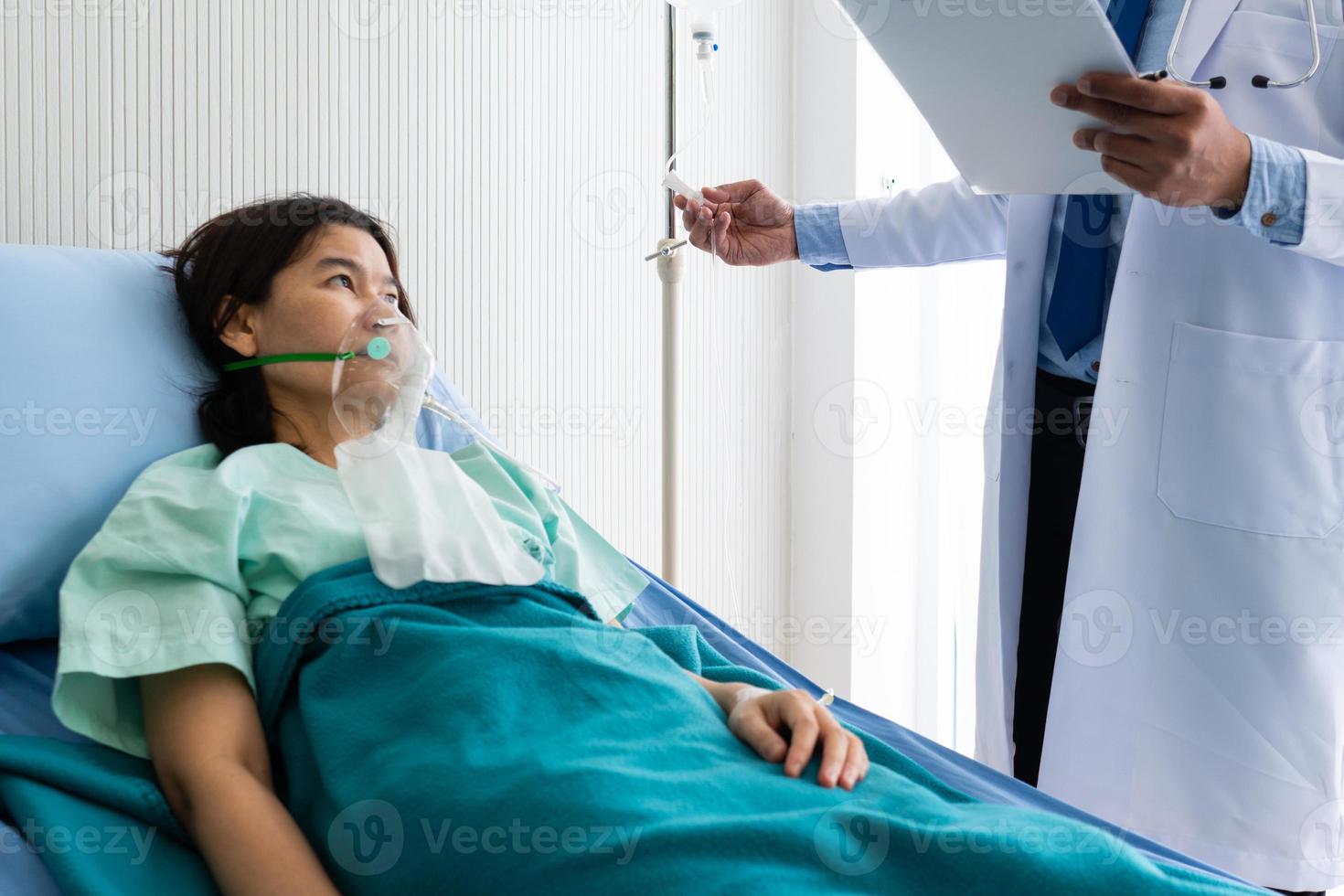 médico dando líquido al paciente que fue admitido en el hospital foto