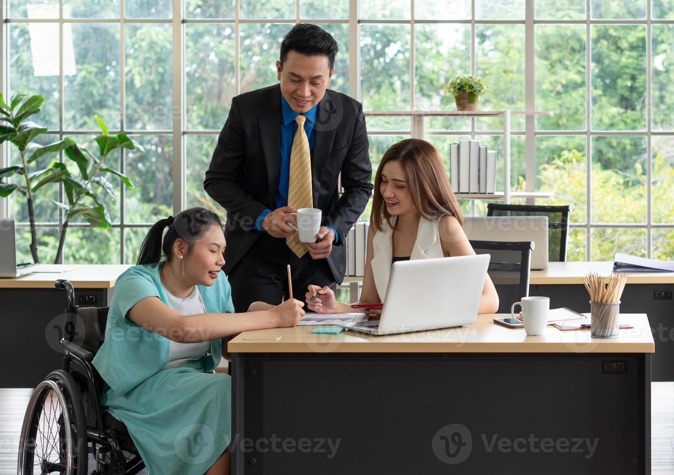 disabled woman sit in wheelchair  discuss project with colleague photo