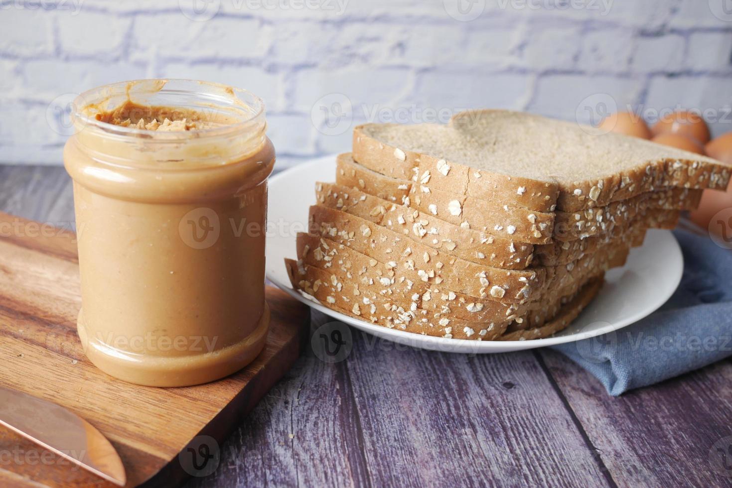 peanut butter and stack of bread on table photo