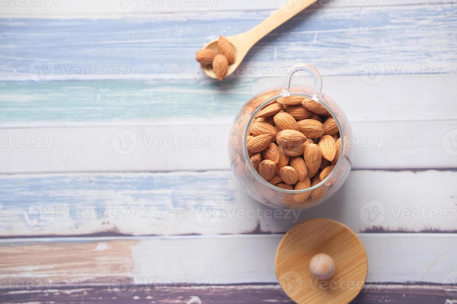 almond nuts in a glass jar on table with copy space photo