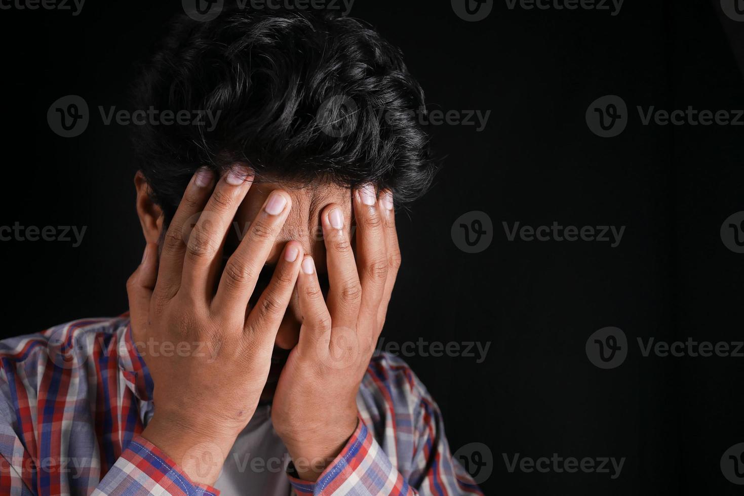 Close up of sad man covering face with hand. photo