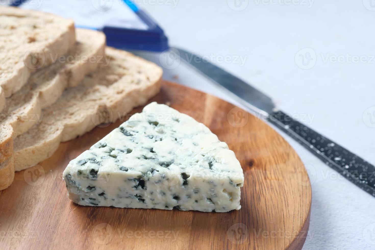 queso azul y rebanada de pan integral en la mesa foto