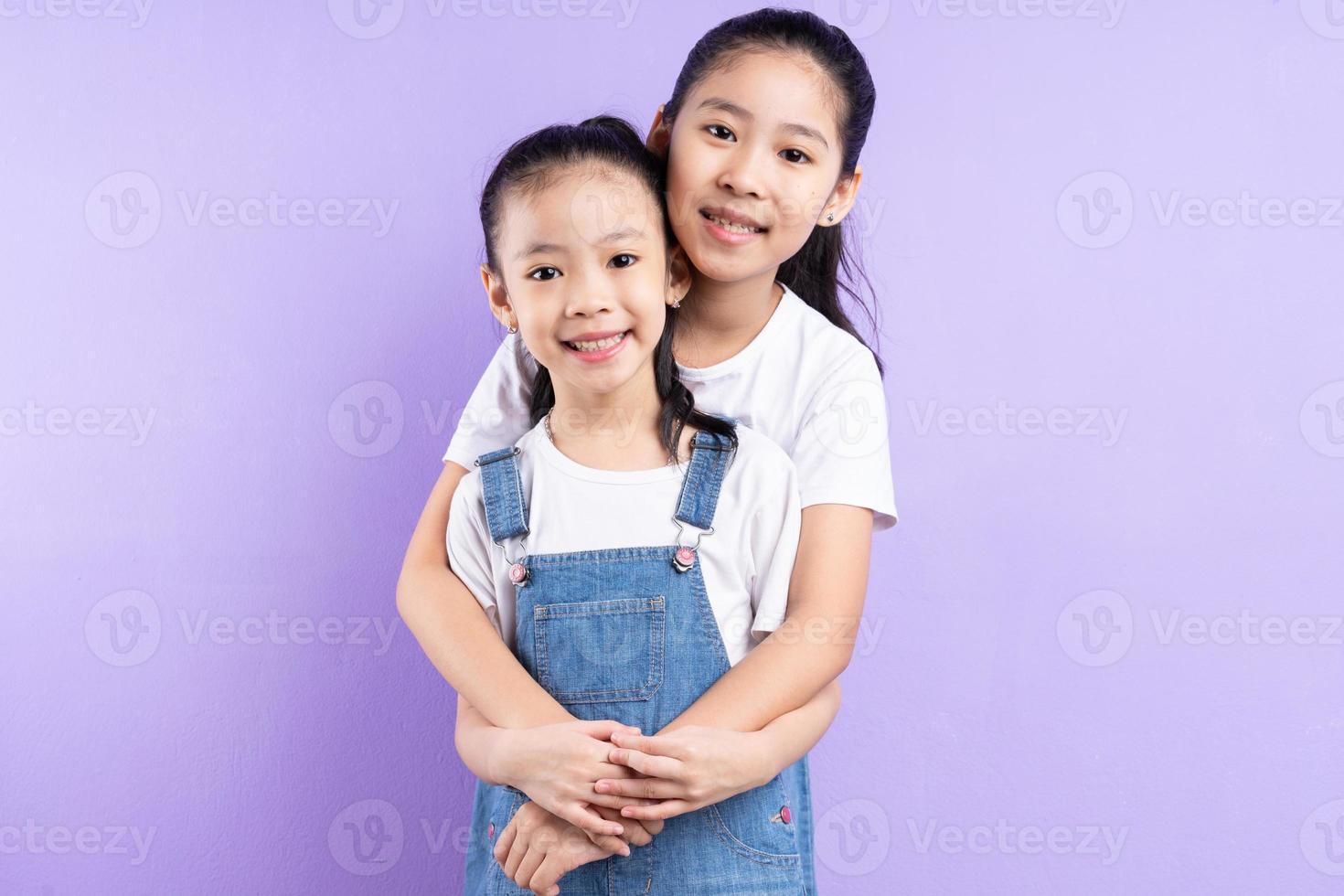 Portrait of two Asian girls on purple background photo