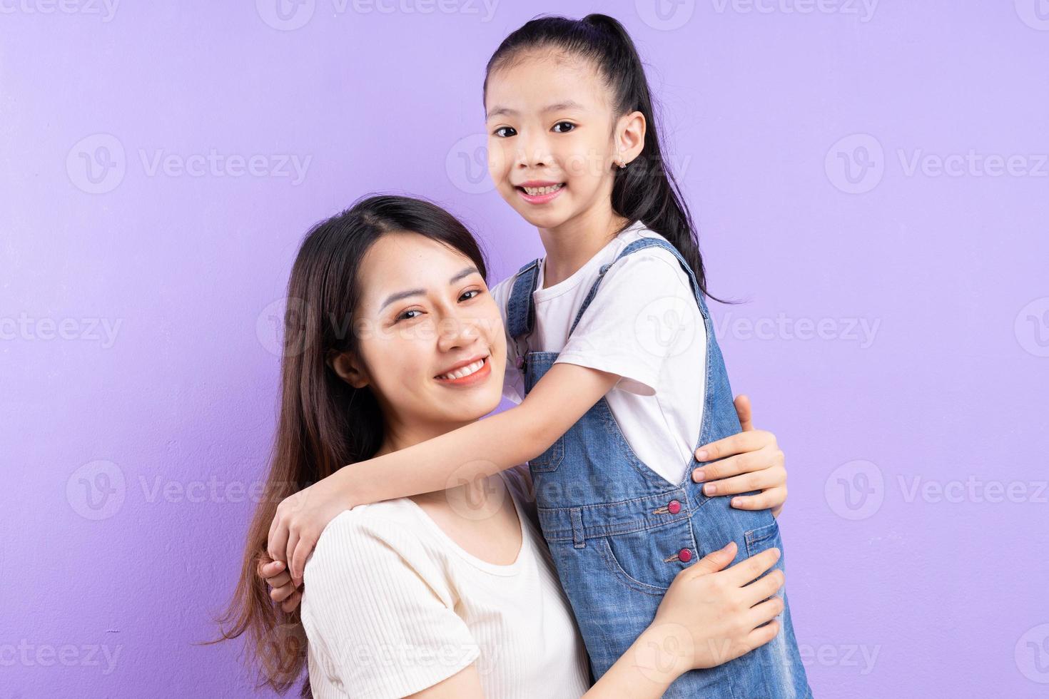 retrato, de, asiático, madre e hija, en, fondo púrpura foto